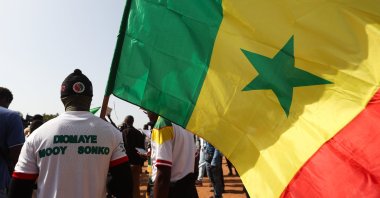 A demonstrator raises Senegal's national flag during a march in Dakar, Senegal, March 2, 2024. (AFP Photo)