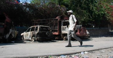 A man walks past carcasses of burnt-out vehicles in front of the police station at Carrefour de l’Aeroport, in Port-au-Prince, Haiti, March 5, 2024. (AFP Photo)