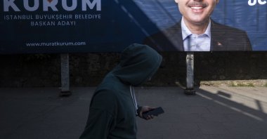 A man walks in front of a local election campaign poster of Istanbul mayoral candidate Murat Kurum of the ruling Justice and Development Party (AK Party) on a street in Istanbul, Türkiye, Feb. 27, 2024. (EPA Photo)