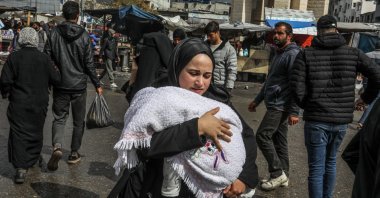 A displaced Palestinian woman carries her baby in Rafah, Gaza Strip, Palestine, March 7, 2024. (AA Photo)