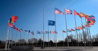 An empty mast amongst member nation flags in the Cour d'Honneur of the NATO headquarters, ahead of a flag-raising ceremony for Sweden’s accession to NATO, Brussels, Belgium, Feb. 27, 2024. (AFP File Photo)