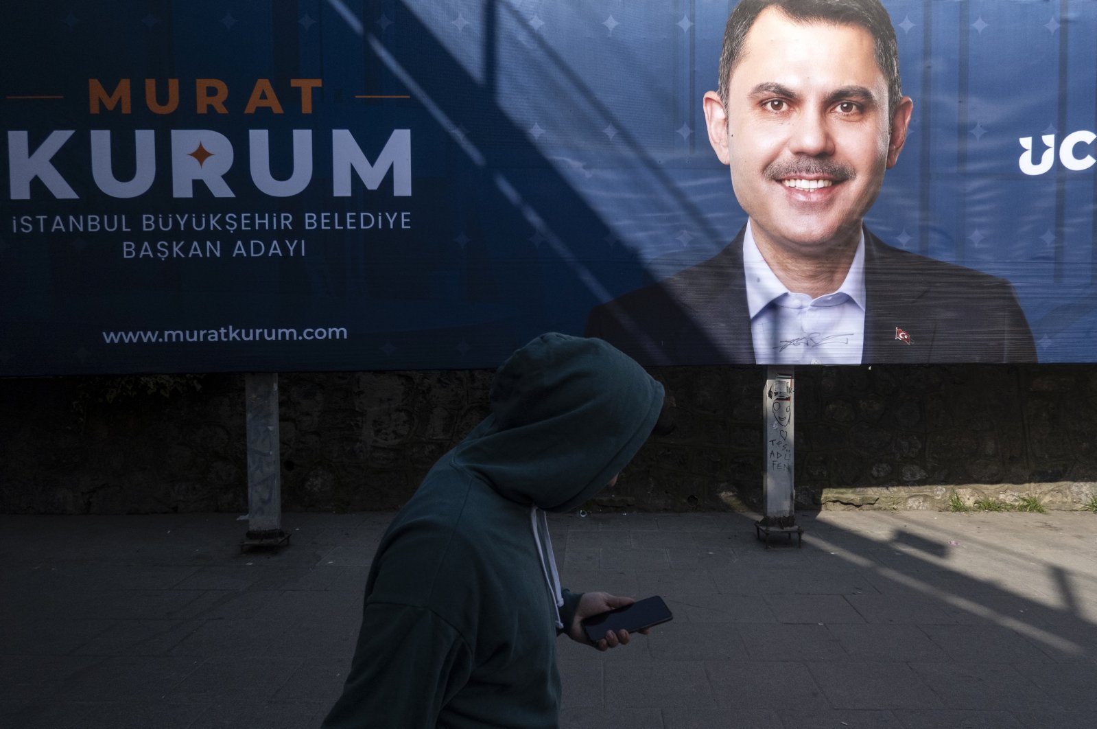 A man walks in front of a local election campaign poster of Istanbul mayoral candidate Murat Kurum of the ruling Justice and Development Party (AK Party) on a street in Istanbul, Türkiye, Feb. 27, 2024. (EPA Photo)