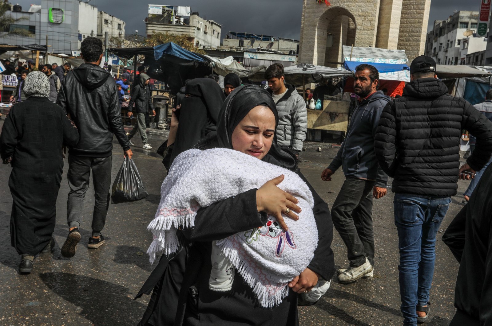 A displaced Palestinian woman carries her baby in Rafah, Gaza Strip, Palestine, March 7, 2024. (AA Photo)