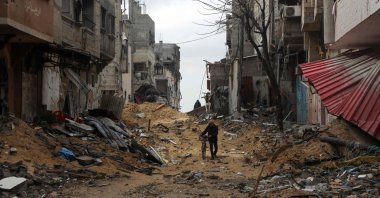 A Palestinian man pushes his bicycle as he walks amid buildings destroyed in Israeli bombing as they flee Khan Yunis in the southern Gaza Strip, Palestine, March 7, 2024. (AFP Photo)