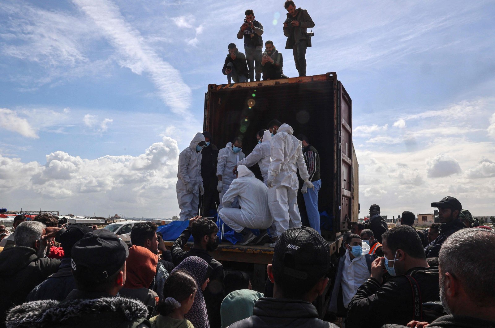 Mourners watch as medical personnel transport the bodies of 47 Palestinians, that were taken and later released by Israel, during a mass funeral in Rafah in the southern Gaza Strip, Palestine, March 7, 2024. (AFP Photo)