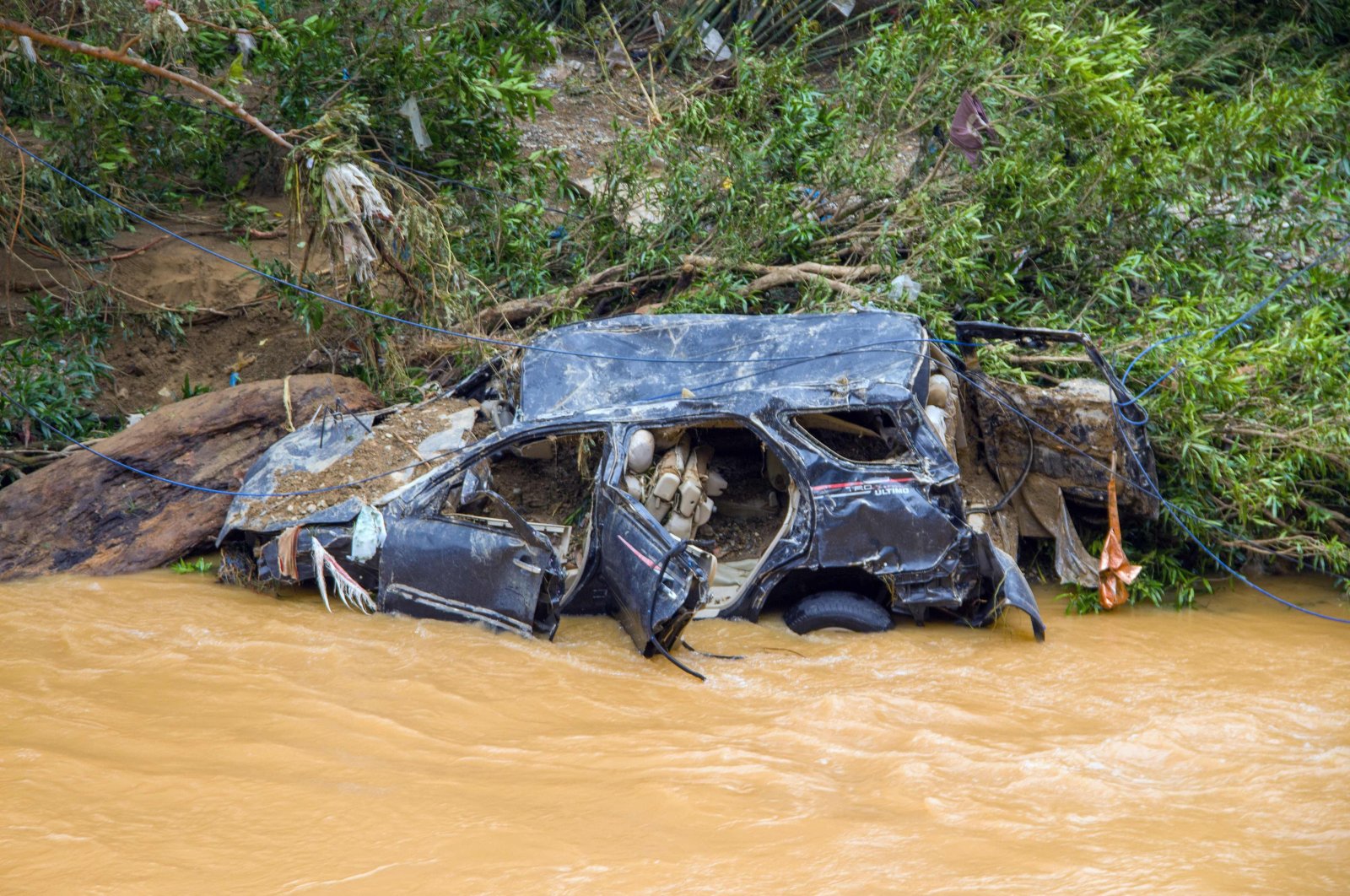 The wreckage of a car swept away by flash flooding is seen by a river bank in Pesisir Selatan Regency, West Sumatra, Indonesia, March 9, 2024. (AFP Photo)