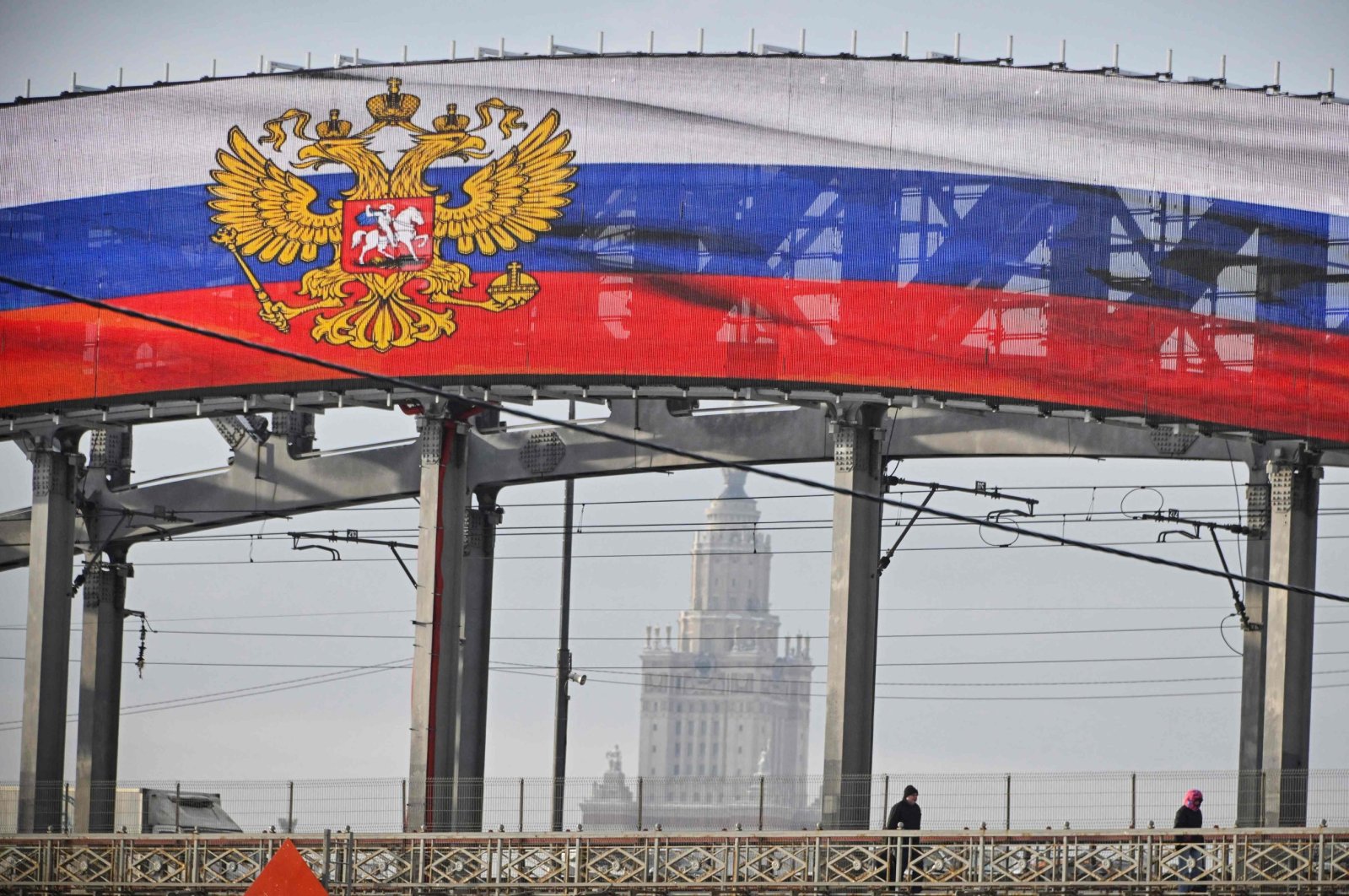 A giant screen displays the Russian state emblem with the Moscow State University in the background, Moscow, Russia, Feb. 14, 2024. (AFP Photo)