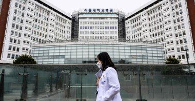 A medical worker walks past the Seoul National University Hospital in Seoul, South Korea, Feb. 21, 2024. (AFP Photo)