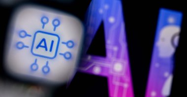 A photo shows the logo of the Artificial Intelligence chat application on a smartphone screen (L) and the letters AI on a laptop screen in Frankfurt, Germany, Feb. 26, 2024. (AFP Photo)