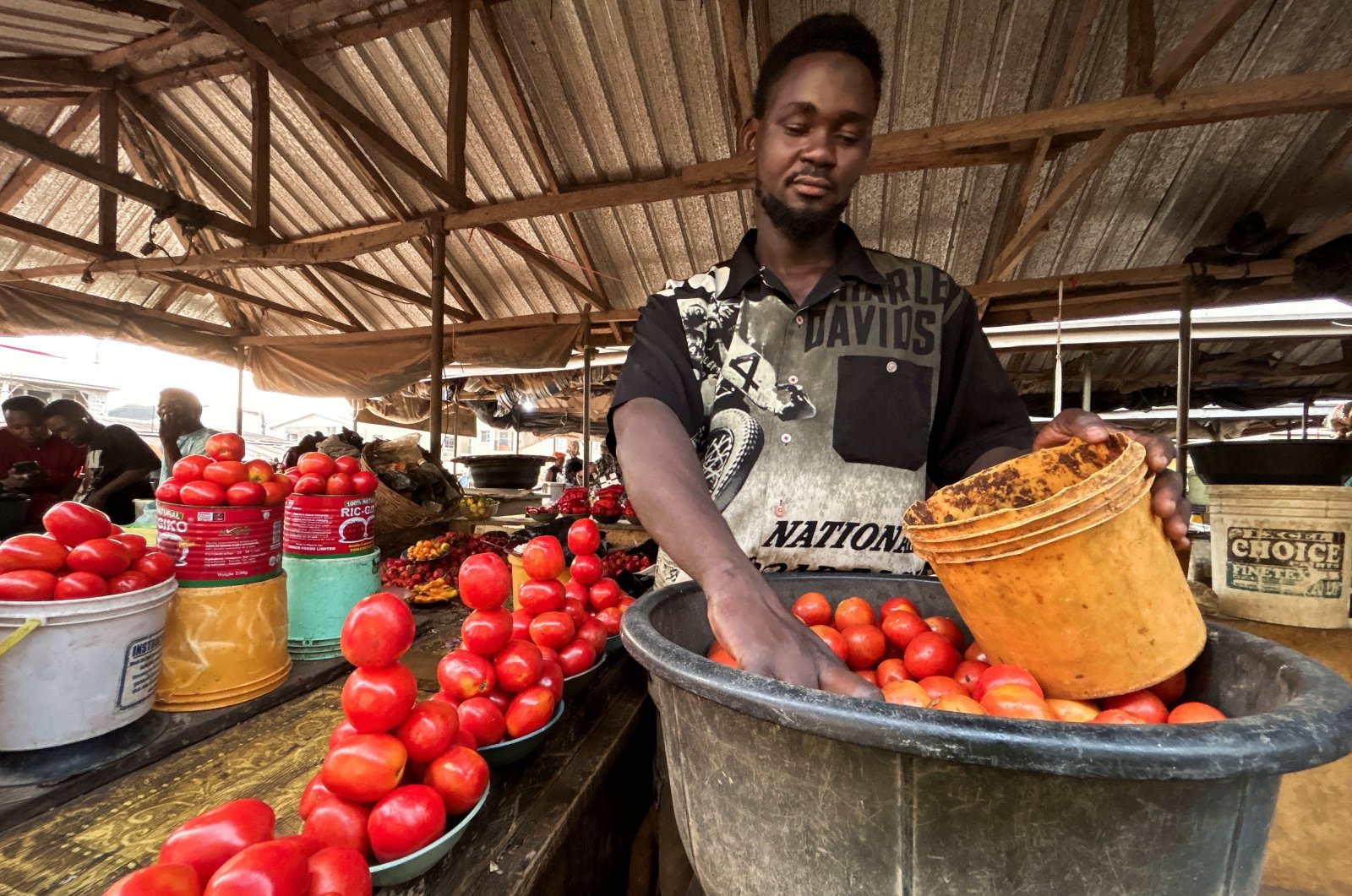 Farouk Dalhatu, a tomato seller attends to a buyer in a community market of Agodo, Lagos, Nigeria, March 6, 2024. (Reuters Photo)