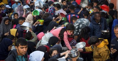 Displaced Palestinians collect food donated by a charity before an iftar meal, the breaking of the fast, on the first day of the Muslim holy fasting month of Ramadan, Rafah, Gaza Strip, Palestine, March 11, 2024. (AFP Photo)