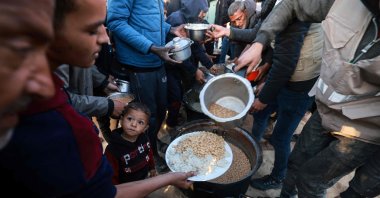 Displaced Palestinians collect food donated by a charity in Rafah, southern Gaza Strip, Palestine, March 11, 2024. (AFP Photo)