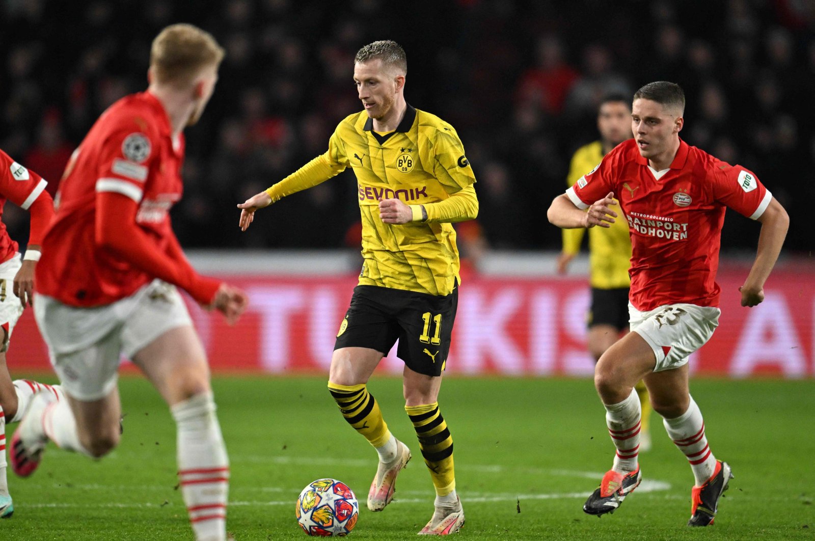 Borussia Dortmund&#039;s Marco Reus (C) plays the ball chased by PSV&#039;s Joey Veerman during the UEFA Champions League round of 16, first leg football match at the Philips Stadium, Eindhoven, Netherlands, Feb. 20, 2024. (AFP Photo)