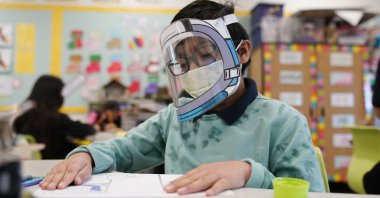 A student wears a mask and face shield at an elementary school in Lynwood, California, U.S. Jan. 12, 2022. (AP Photo)