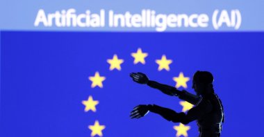 The words "Artificial intelligence (AI)," a miniature robot and the EU flag are seen in this illustration taken Dec. 21, 2023. (Reuters Photo)