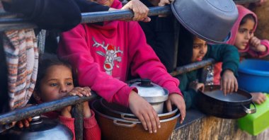 Palestinians wait to receive food during the Muslim holy fasting month of Ramadan, as the conflict between Israel and Hamas continues, in Rafah, in the southern Gaza Strip March 13, 2024. (Reuters Photo)