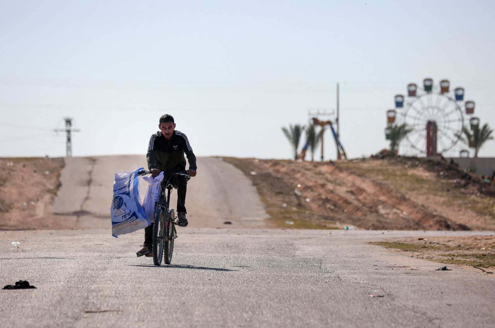 A displaced Palestinian man flees on his bicycle the Hamad City area in Khan Younis in the southern Gaza Strip, Palestine, March 5, 2024. (AFP Photo)