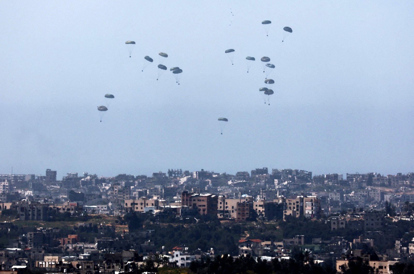 This picture taken from Israel&#039;s southern border with the Gaza Strip shows humanitarian aid being airdropped over the Palestinian territory on March 13, 2024. (AFP Photo)