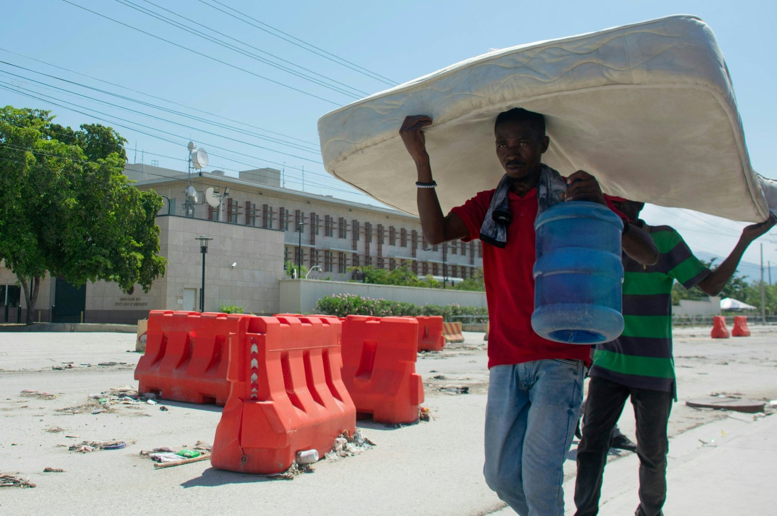 Two people carry a mattress as they walk past the U.S. embassy in Port-au-Prince, Haiti, March 12, 2024. (AFP Photo)