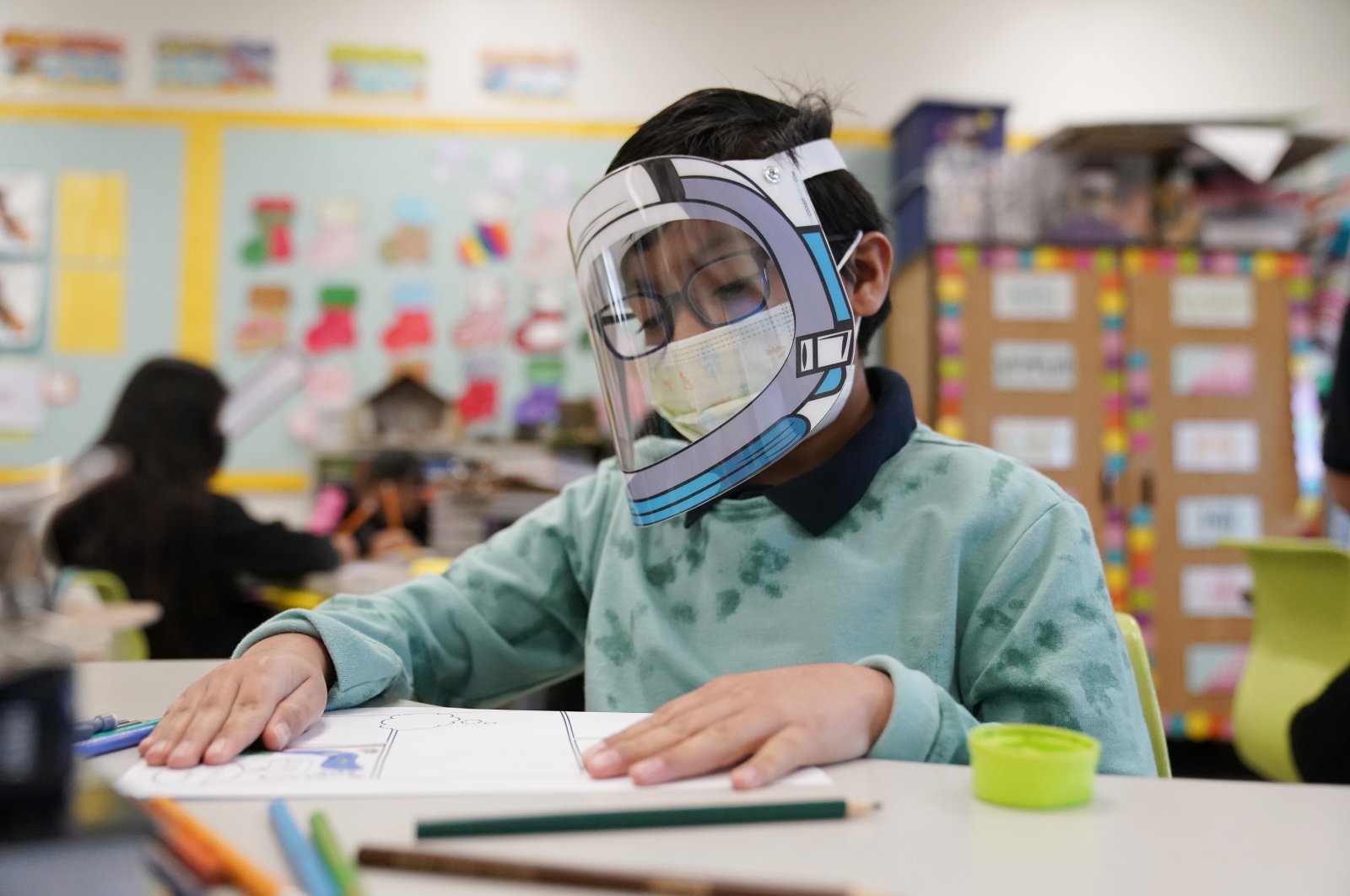 A student wears a mask and face shield at an elementary school in Lynwood, California, U.S. Jan. 12, 2022. (AP Photo)