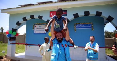 A staff member of the Presidency of Religious Affairs (Diyanet) cheers with a local boy during the opening ceremony of a water well, Bungoma, Kenya, March 13, 2024. (AA Photo)