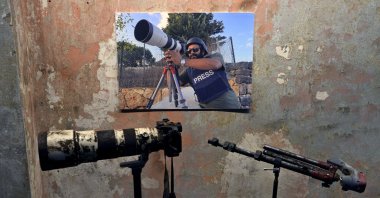 A poster of Reuters videographer Issam Abdallah, who was killed by Israeli shelling on Oct. 13, 2023, with his camera and tripod is displayed during a press conference by Amnesty International and Human Rights Watch in Beirut, Lebanon, Dec. 7, 2023. (AP Photo)