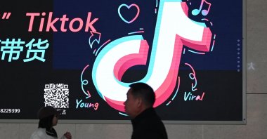People walk past an advertisement featuring the TikTok logo at a train station in Zhengzhou, in China’s central Henan province on Jan. 21, 2024. (AFP File Photo)