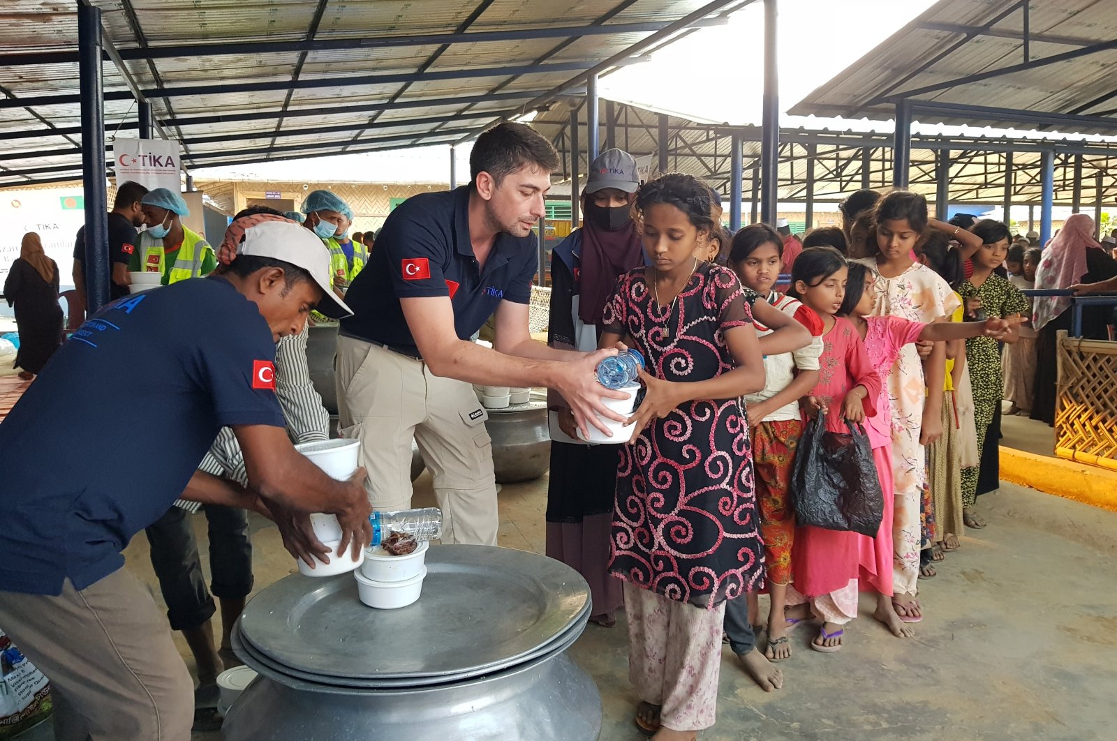 Staff of the Turkish Cooperation and Coordination Agency (TIKA) provide food as part of the iftar program for refugees in Cox&#039;s Bazar, Bangladesh, March 13, 2024. (AA Photo)