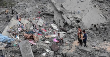 Children sit among the rubble and scattered belongings of the Palestinian al-Atrash family, after their home was destroyed in an Israeli strike in Deir el-Balah in the central Gaza Strip, Palestine, March 13, 2024. (AFP Photo)
