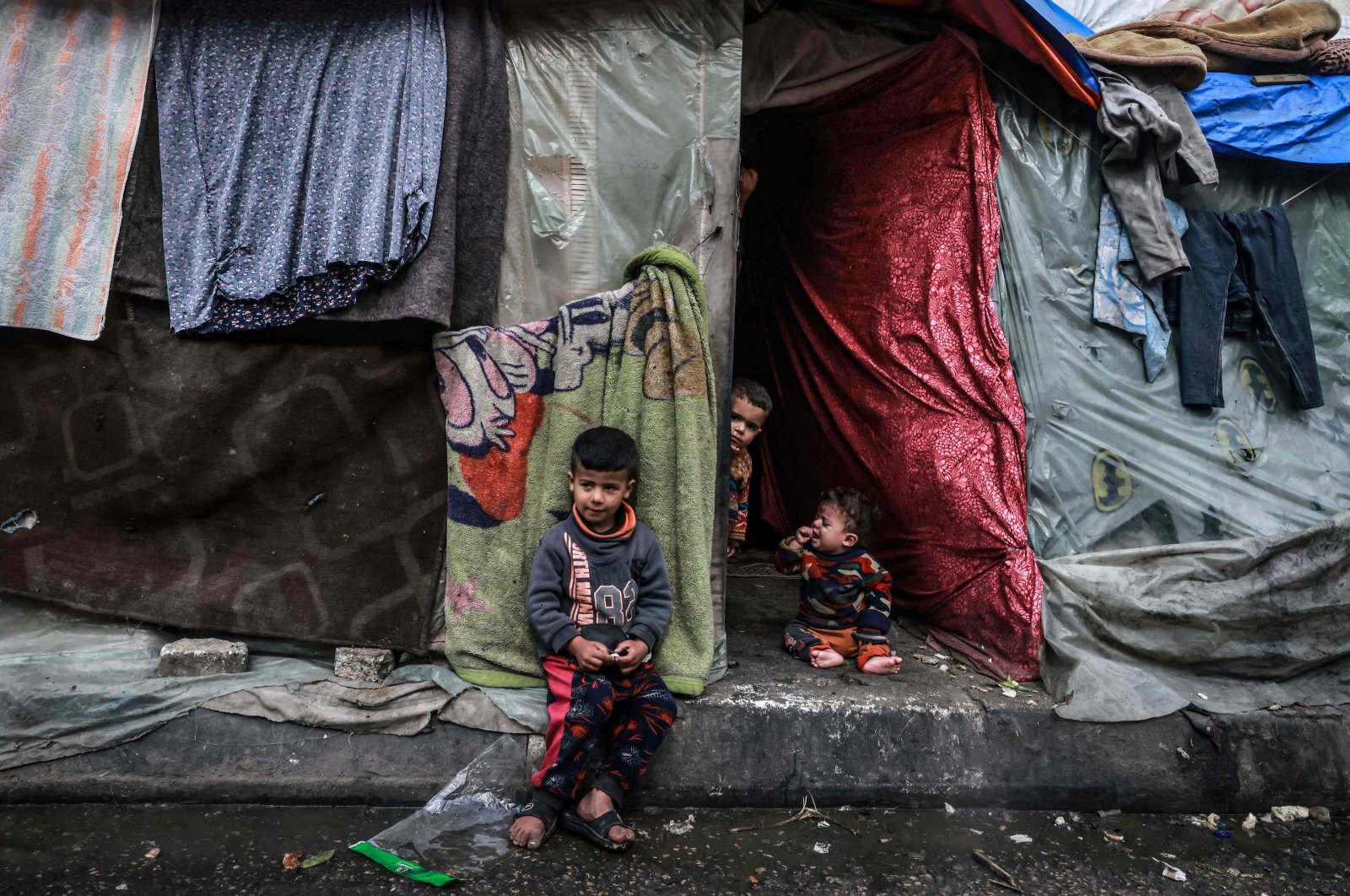 Displaced Palestinian children wait in front of their makeshift tent at a camp beside a street in Rafah, southern Gaza, Palestine, March 14, 2024. (AFP Photo)
