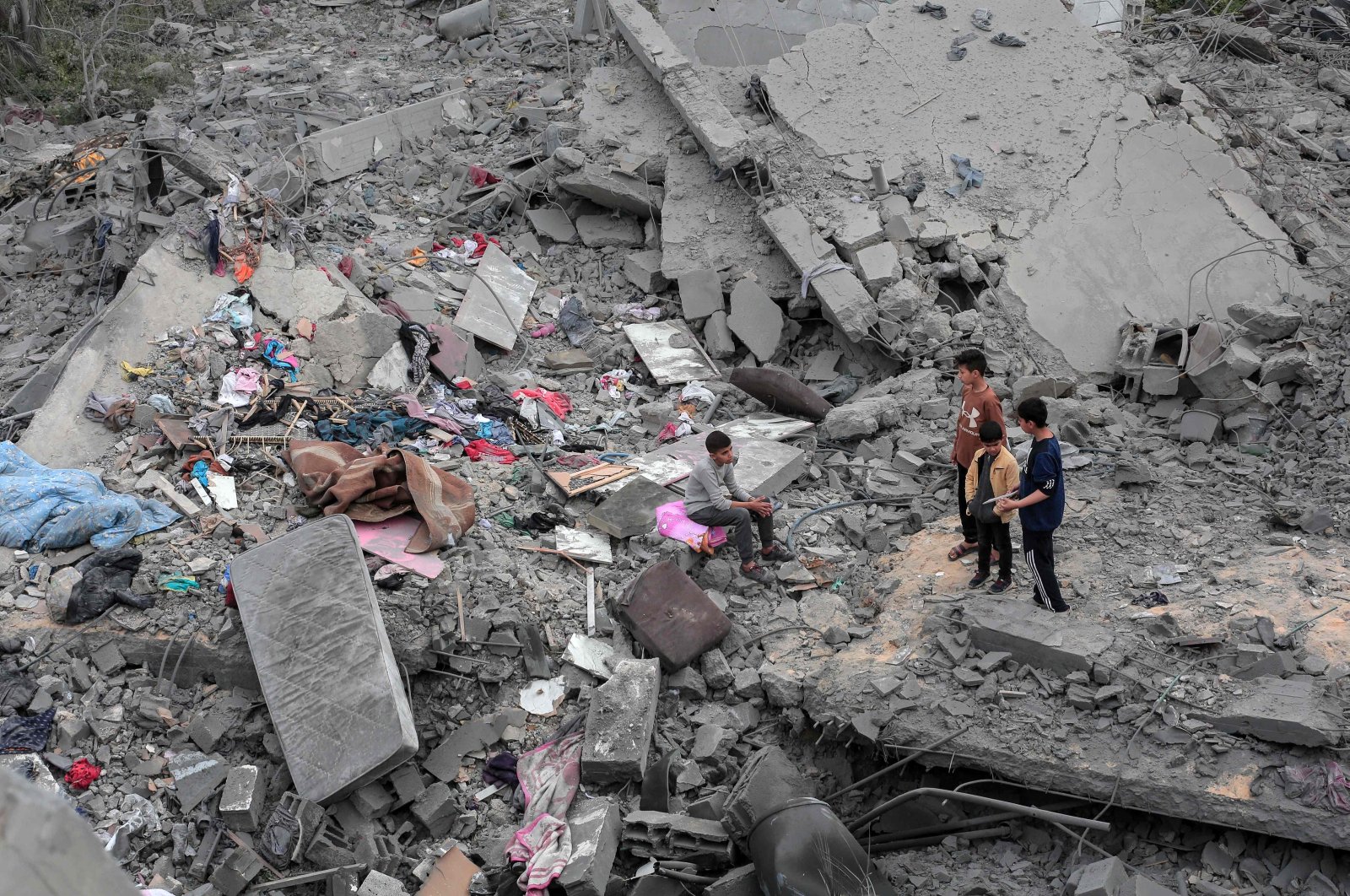 Children sit among the rubble and scattered belongings of the Palestinian al-Atrash family, after their home was destroyed in an Israeli strike in Deir el-Balah in the central Gaza Strip, Palestine, March 13, 2024. (AFP Photo)