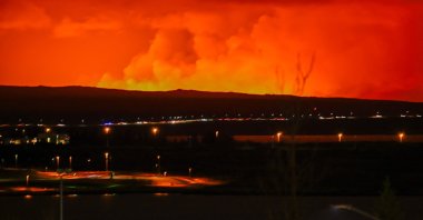 Molten lava flows from a fissure on Iceland&#039;s Reykjanes peninsula, turning the sky orange, near Grindavik, Iceland, March 16, 2024. (AFP Photo)