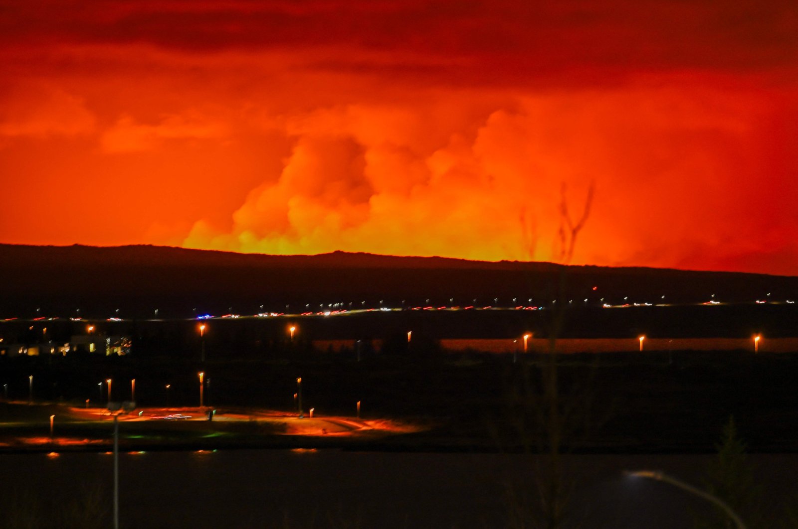 Molten lava flows from a fissure on Iceland&#039;s Reykjanes peninsula, turning the sky orange, near Grindavik, Iceland, March 16, 2024. (AFP Photo)