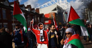 Manchester United fans carrying the flag of Palestine and a cardboard cutout of former player Eric Cantona are pictured outside Old Trafford stadium before the match against Fulham, Manchester, U.K., Feb. 24, 2024. (Reuters Photo)