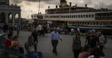 People walk along a promenade next to the Bosporus at Kadıköy ferry terminal in Istanbul, Türkiye, Sept. 27, 2023. (AP Photo)