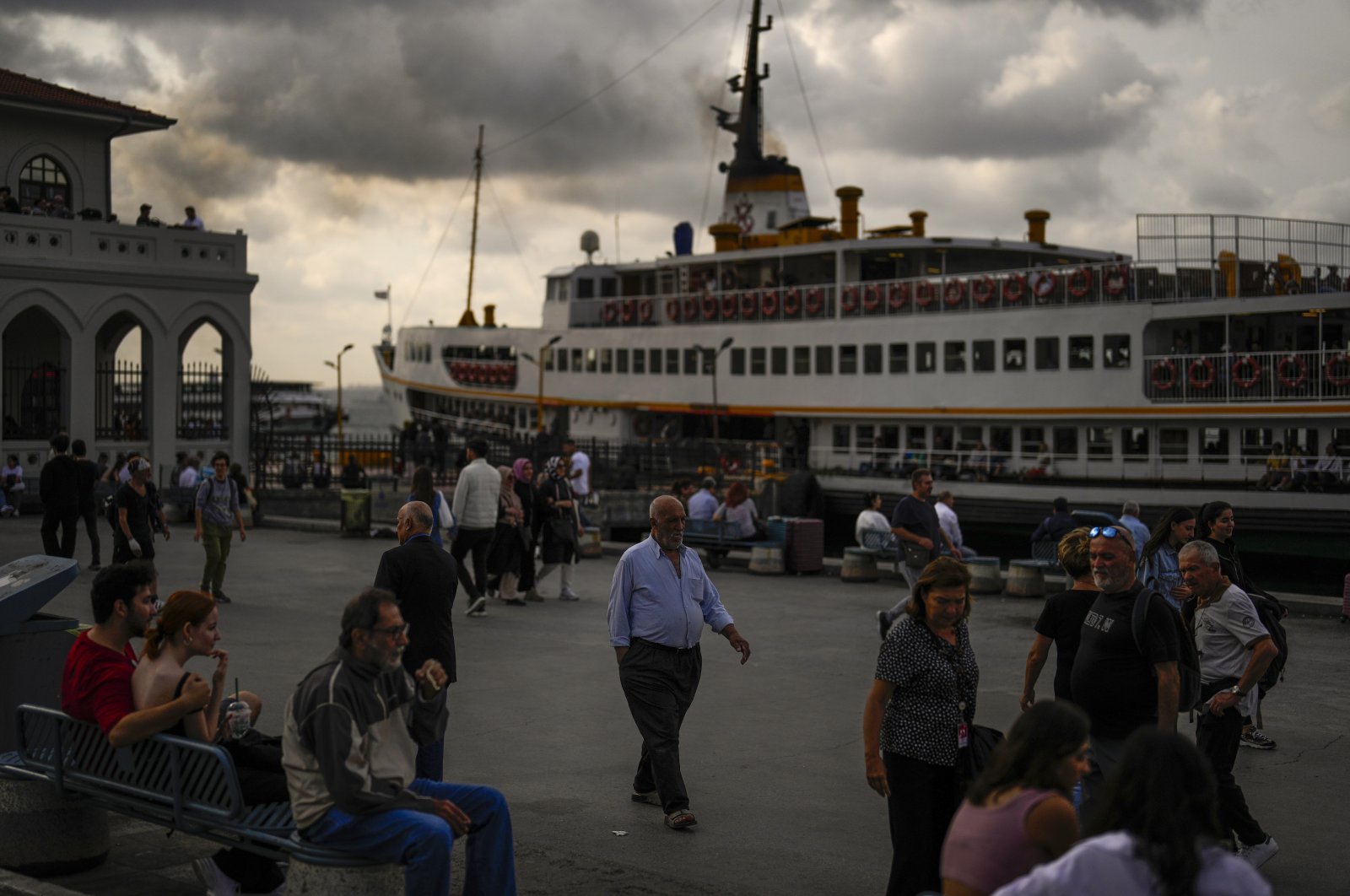 People walk along a promenade next to the Bosporus at Kadıköy ferry terminal in Istanbul, Türkiye, Sept. 27, 2023. (AP Photo)