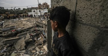 A boy watches as Palestinians search for missing people under the rubble of the destroyed house of the Al Hajj family following an Israeli air strike, in Al Nusairat refugee camp, southern Gaza Strip, Palestine, March 19, 2024. (EPA Photo)