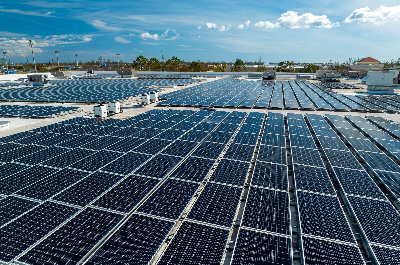 Aerial view of solar panels mounted on an industrial building roof used in producing clean electricity. (Shutterstock Photo)