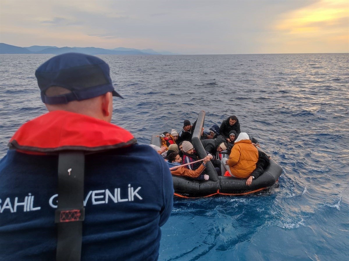 A Turkish coast guard boat pulls up to a group of irregular migrants on a life raft, off the coast of Muğla province, Türkiye, March 19, 2024. (DHA Photo)