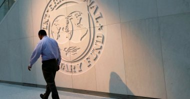 A man walks past the International Monetary Fund (IMF) logo at its headquarters, Washington, U.S., May 10, 2018. (Reuters Photo)