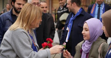 Ilknur Kovaç Bayraktar (L), the ruling Justice and Development Party's (AK Party) mayoral candidate for an Istanbul district, hands out flowers to citizens during a neighborhood tour, Istanbul, Türkiye, March 20, 2024. (IHA Photo)