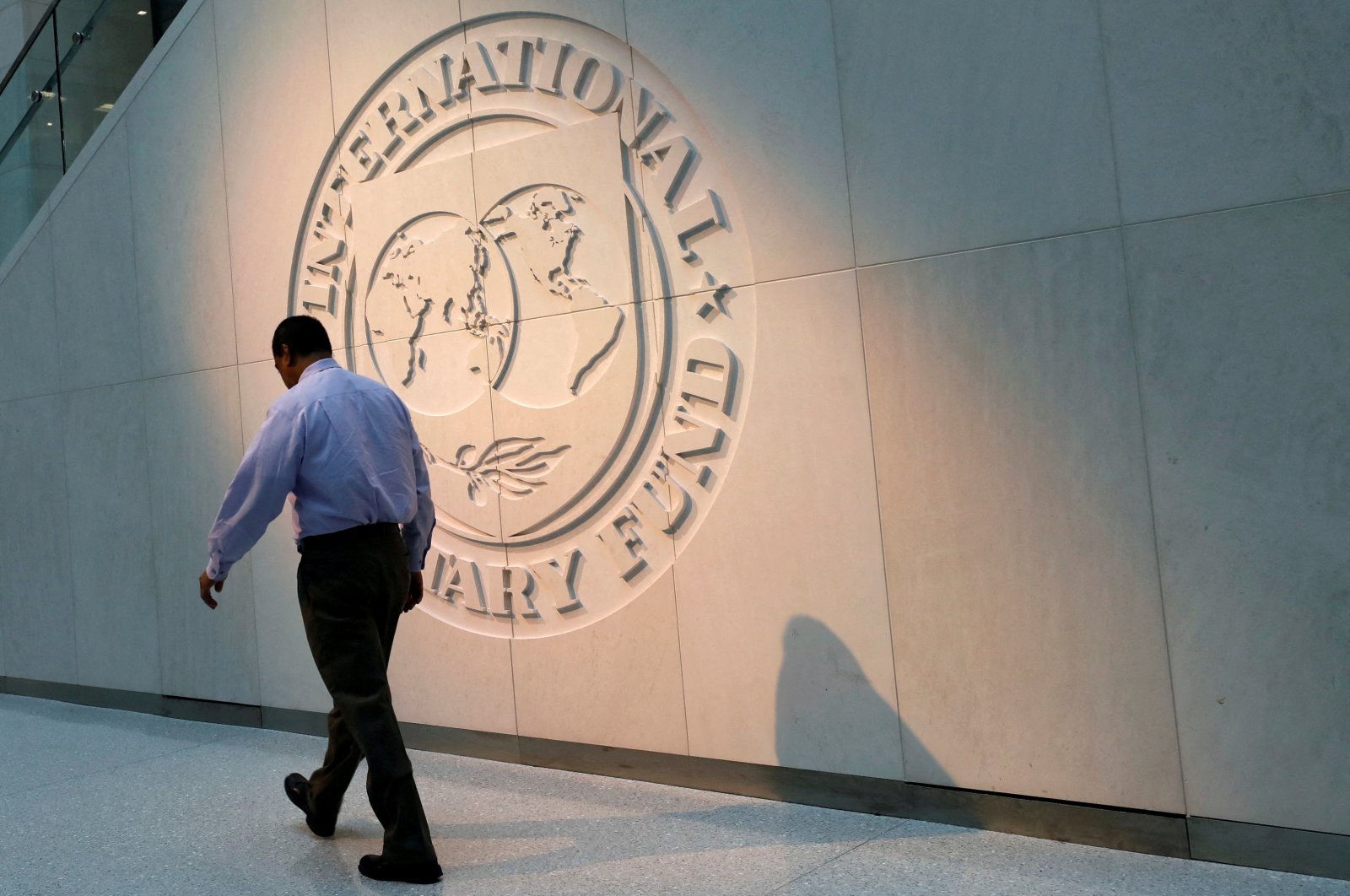 A man walks past the International Monetary Fund (IMF) logo at its headquarters, Washington, U.S., May 10, 2018. (Reuters Photo)