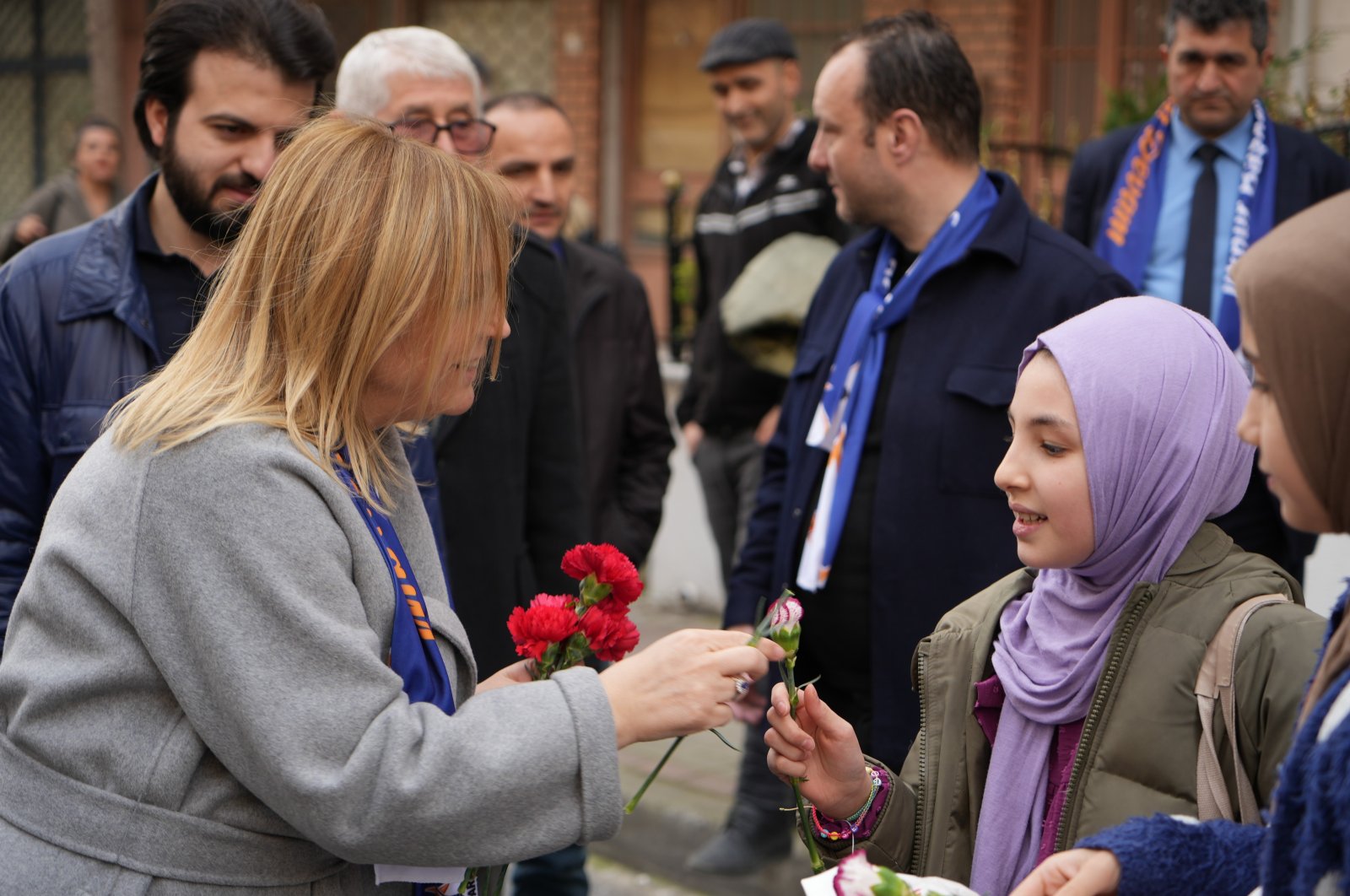 Ilknur Kovaç Bayraktar (L), the ruling Justice and Development Party&#039;s (AK Party) mayoral candidate for an Istanbul district, hands out flowers to citizens during a neighborhood tour, Istanbul, Türkiye, March 20, 2024. (IHA Photo)