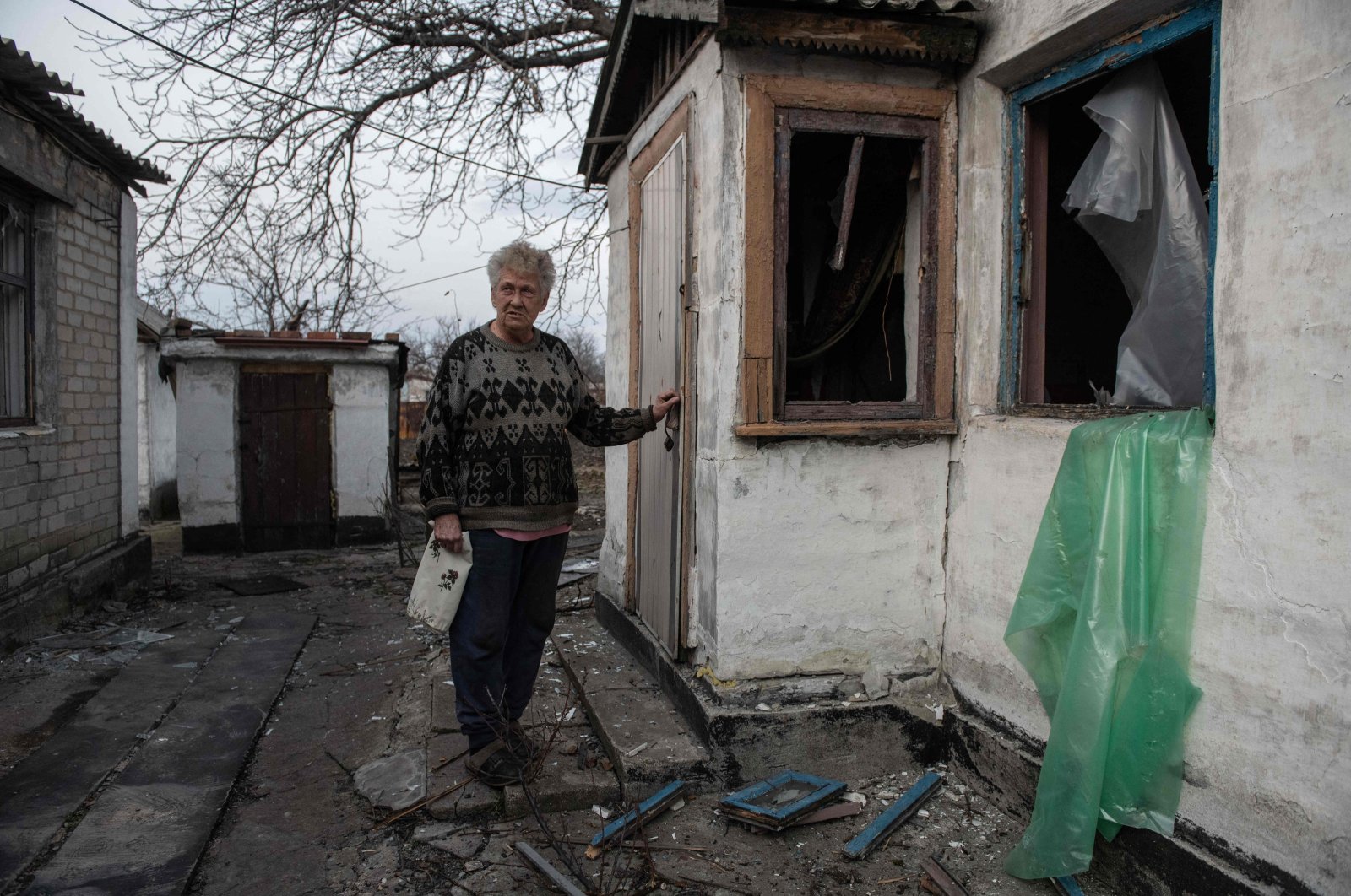 A local resident is seen outside a damaged house following a recent shelling amid the ongoing Russian-Ukrainian conflict, Donetsk, Russian-controlled Ukraine, on March 19, 2024. (AFP Photo)