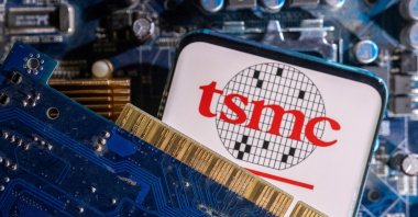 A smartphone with a displayed Taiwan Semiconductor Manufacturing Company (TSMC) logo is placed on a computer motherboard in this illustration taken on March 6, 2023. (Reuters Photo)