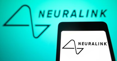 In this photo illustration, the Neuralink logo is displayed on a smartphone screen and in the background, Feb. 4, 2024. (Reuters File Photo)