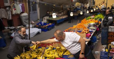 A food seller attends a client at a street market in Istanbul, Türkiye, March 19, 2024. (AP Photo)