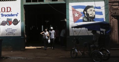 Shoppers exit a state-run agro-market, where a mural of Fidel Castro adorns the facade, in Havana, Cuba, March 7, 2024. (AP Photo)