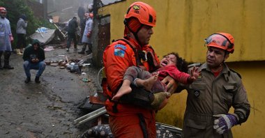 Brazilian emergency workers carry a girl, who was rescued after more than 12 hours under the rubble of her house destroyed by the heavy rains in Petropolis, Brazil, March 23, 2024. (AFP Photo)
