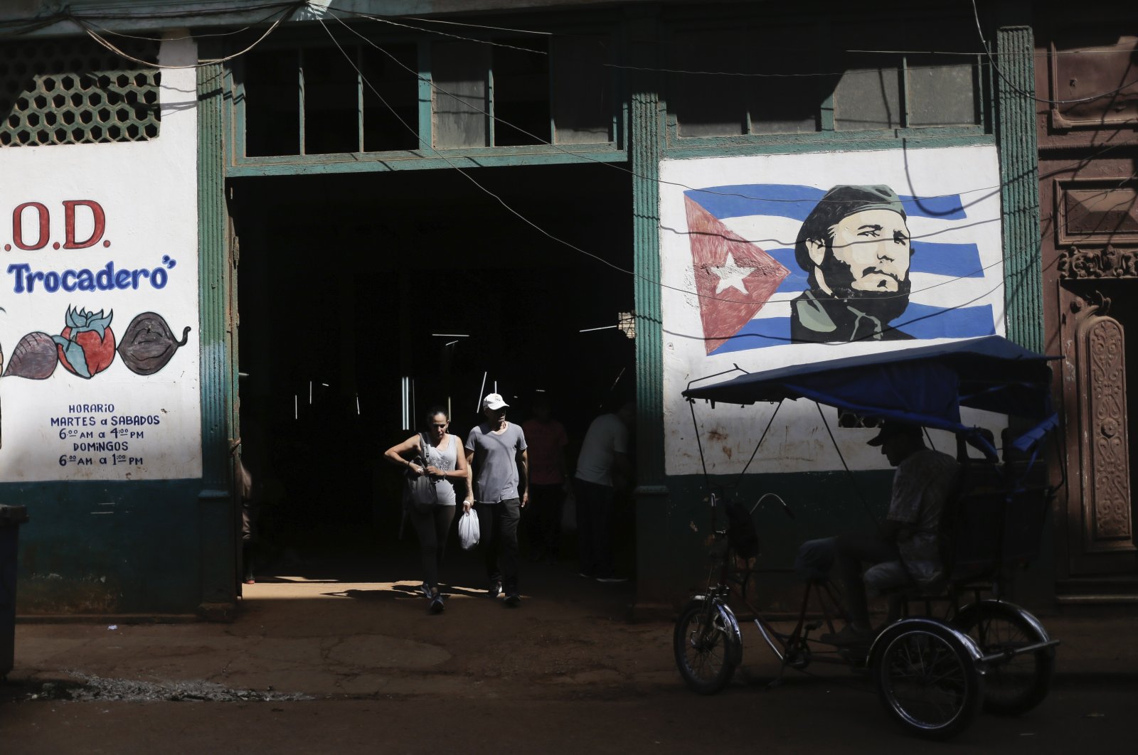 Shoppers exit a state-run agro-market, where a mural of Fidel Castro adorns the facade, in Havana, Cuba, March 7, 2024. (AP Photo)